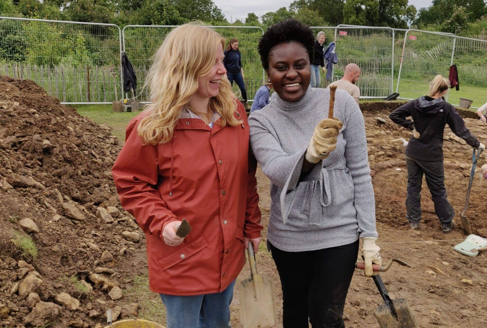 Two people looking at a find, which one of them is holding.