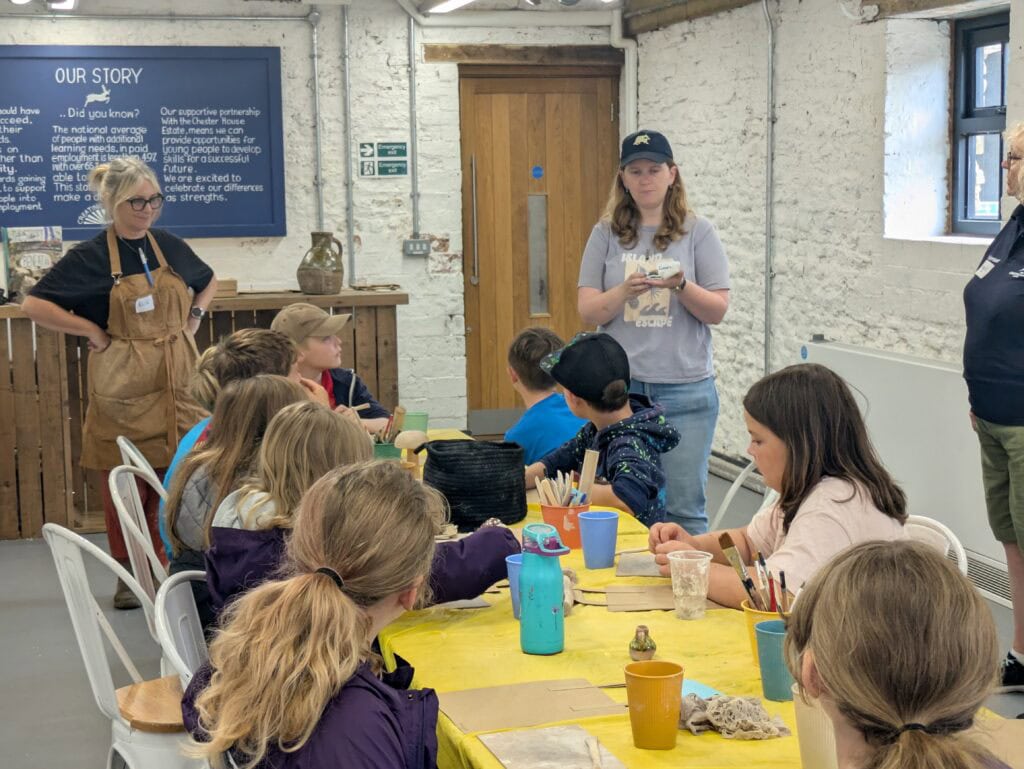 Nine young people sat around a table with pots of paintbrushes.