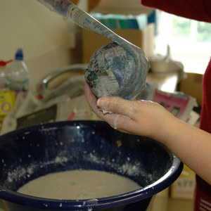 Wrapping a newspaper strip around the newspaper ball to build up the petrosphere.