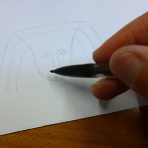 Drawing the head of an Egyptian god for the canopic jar decoration.