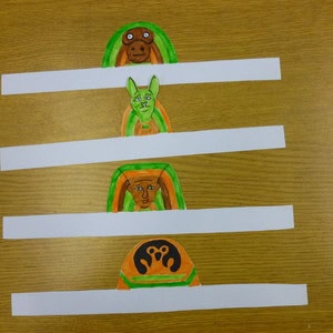 Drawings of Egyptian gods cut out with an attached strip of paper.