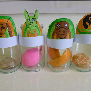 Four completed canopic jar crafts in a line.