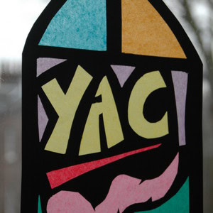 A multi-coloured stained glass window craft that says 'YAC' in bold, central yellow lettering.