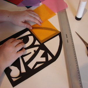 Sizing up yellow tissue paper to the paper frame.