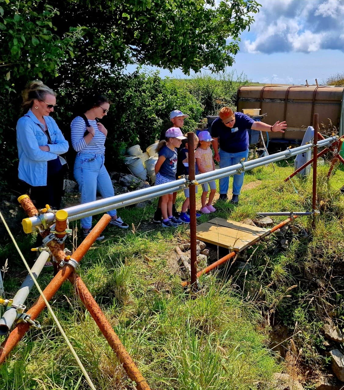A group of adults and young people watching an archaeological dig