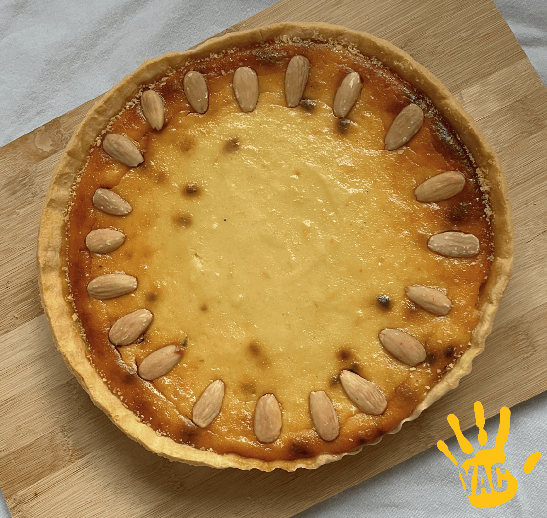 A cheesecake-style tart in a short crust pastry case, decorated with almonds.