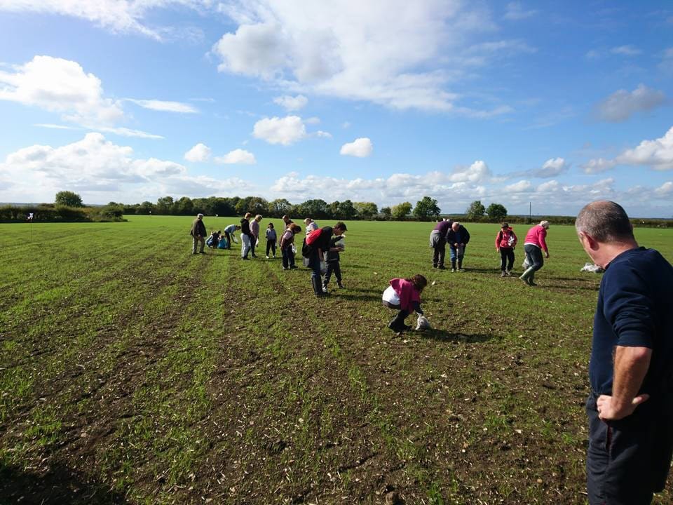 YAC members in a large field picking up objects