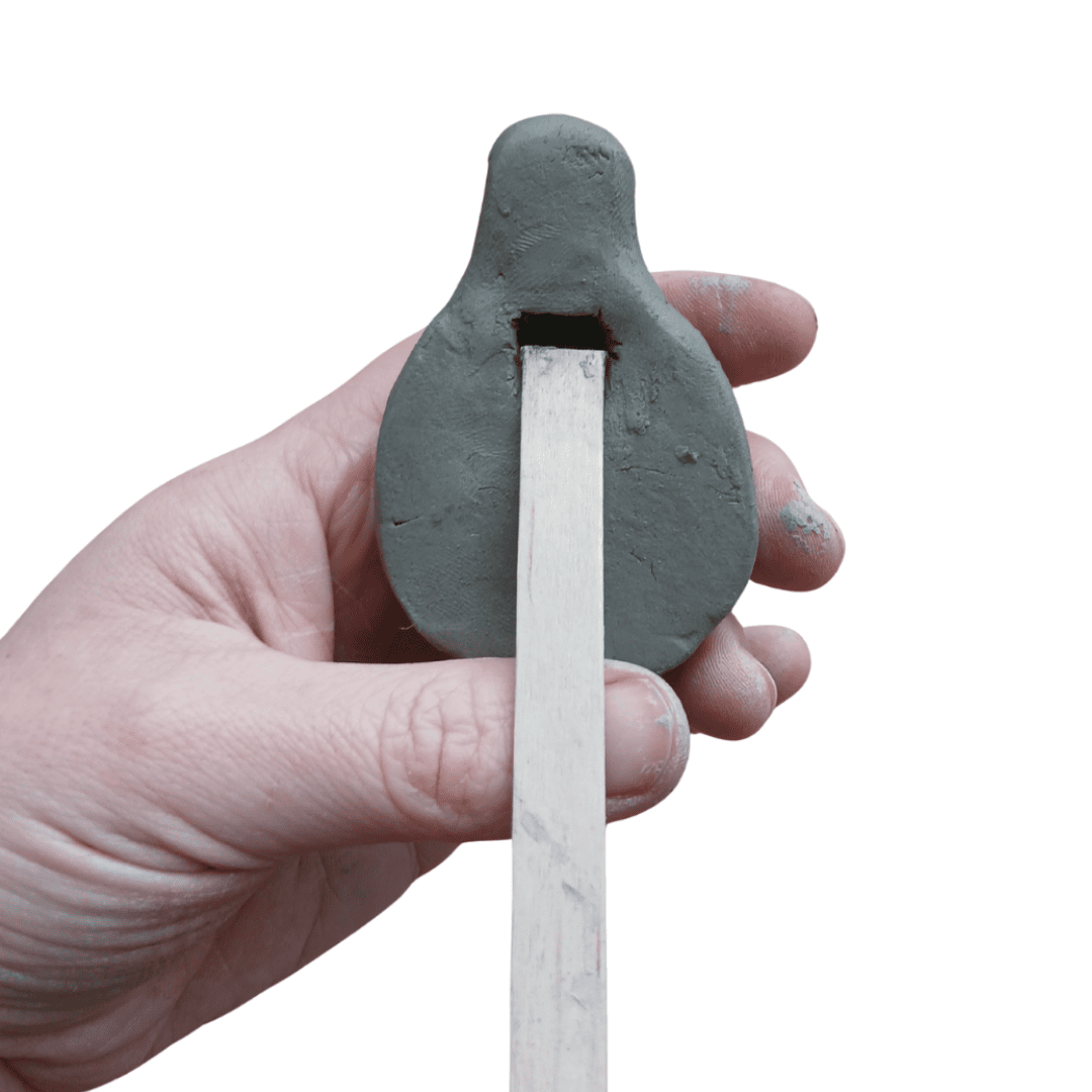 The underside of a round whistle made from clay.