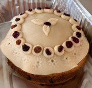 A round cake decorated with marzipan and dried fruit.