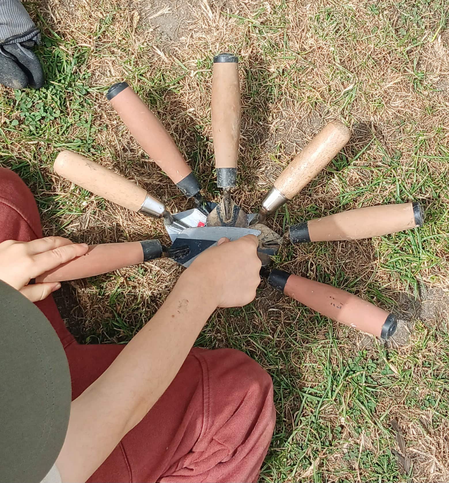 Seven archaeological trowels arranged in a circle