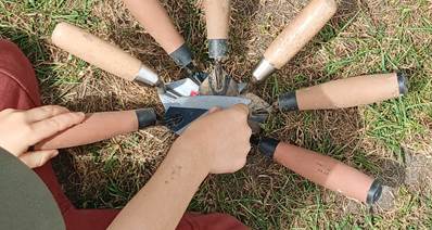 Seven archaeological trowels arranged in a circle