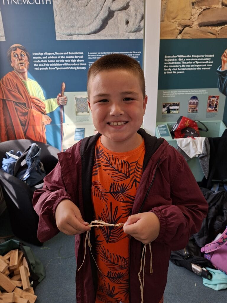 Child smiling and holding his corded rope